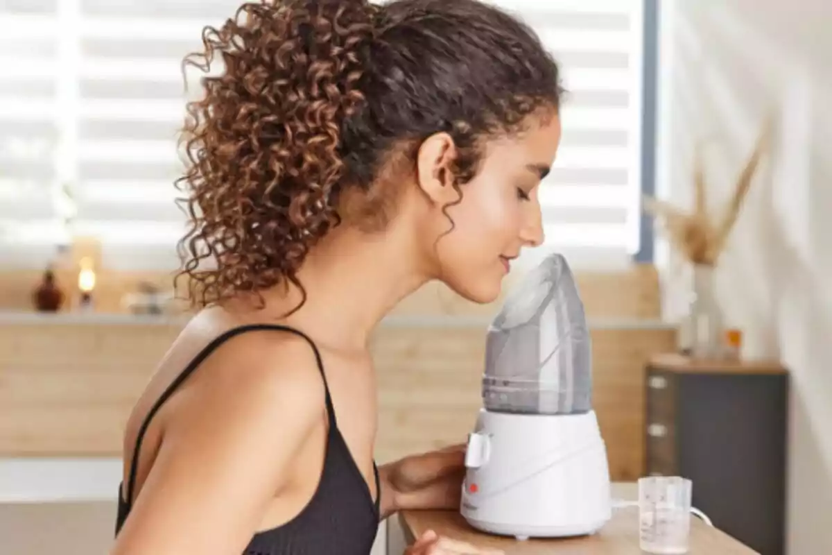Dona usant un vaporitzador facial de Lidl en un ambient relaxat. Dona usant un vaporitzador facial de Lidl en un ambient relaxat.