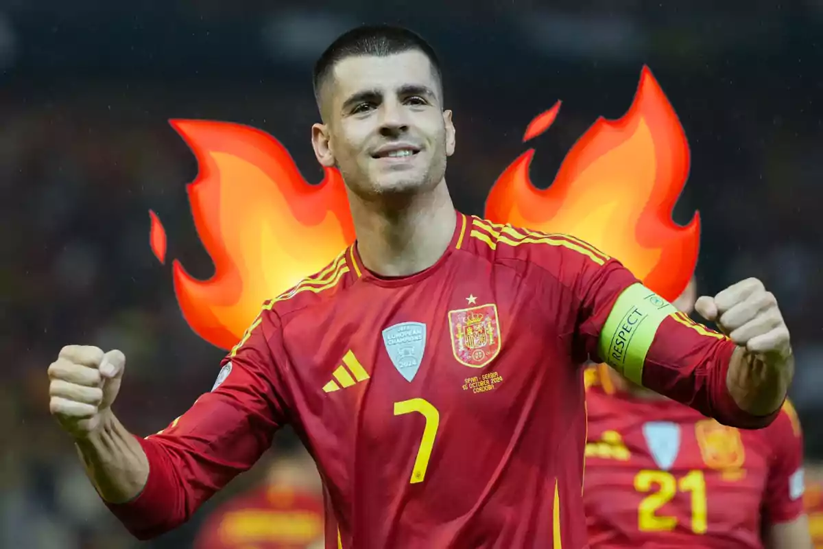 Jugador de fútbol con uniforme rojo celebrando con los puños cerrados y un fondo de llamas.