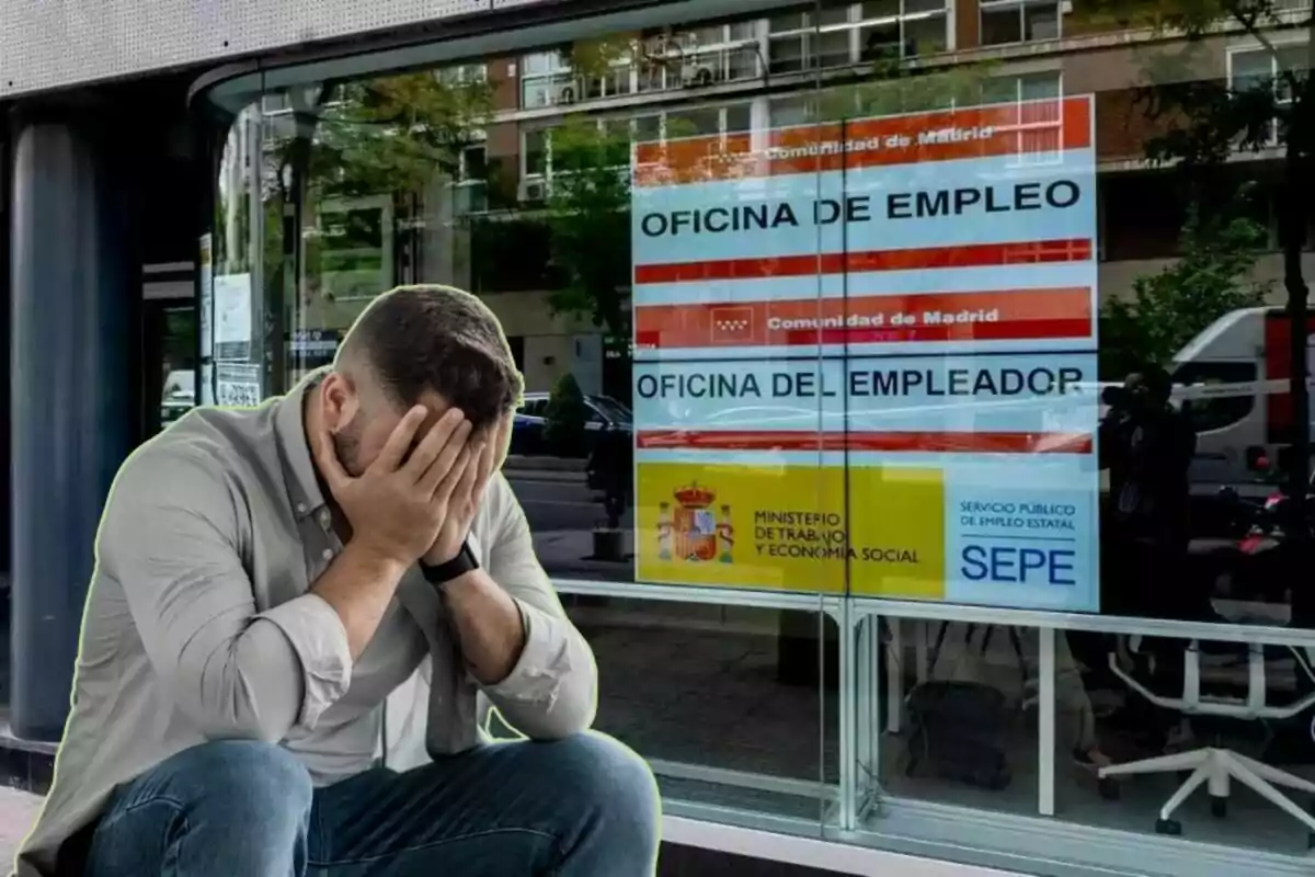 Un home amb les mans a la cara assegut davant d?una oficina d?ocupació a Madrid.