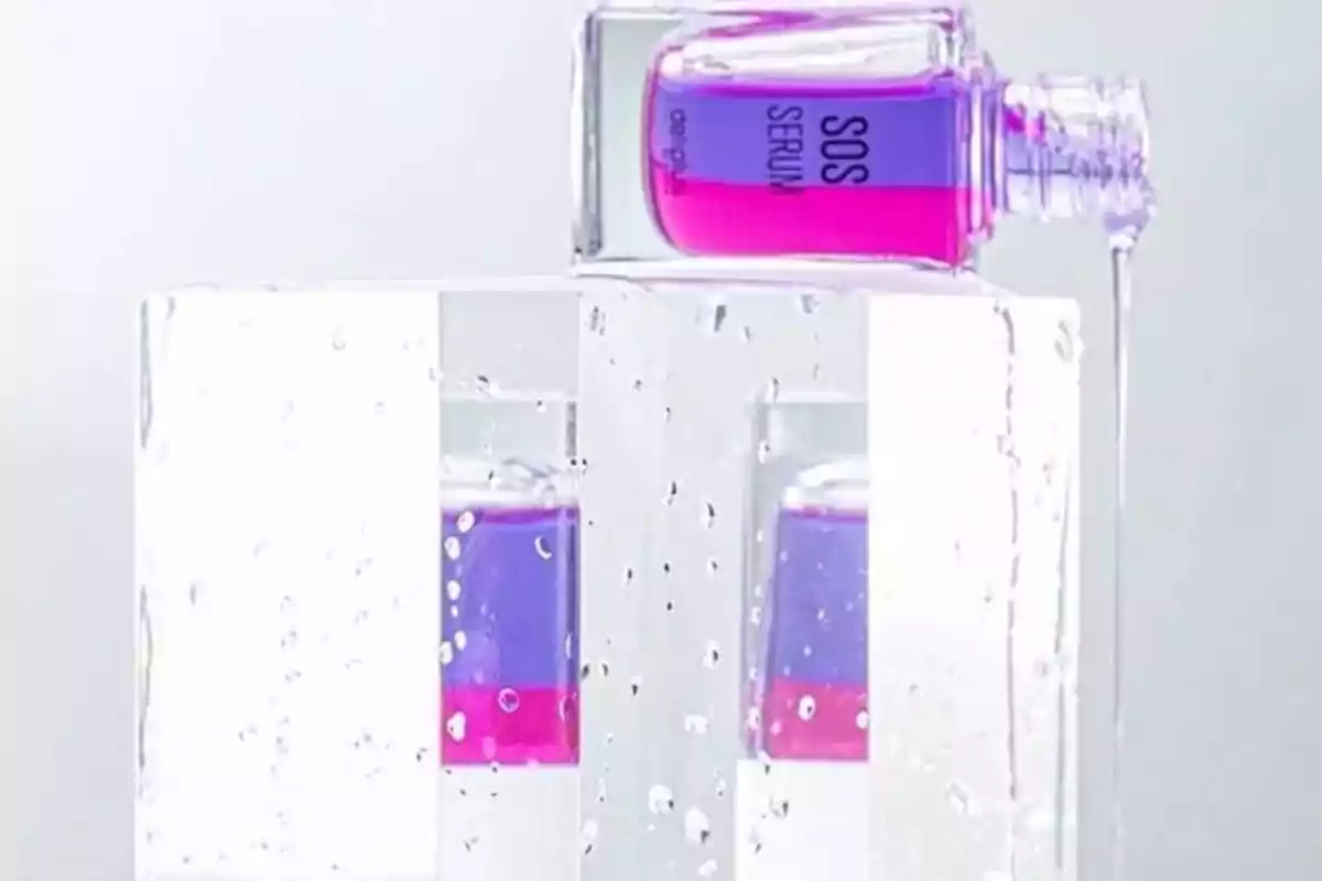 Botella de suero SOS de color púrpura y rosa sobre bloques de hielo con gotas de agua. Botella de suero SOS de color púrpura y rosa sobre bloques de hielo con gotas de agua.