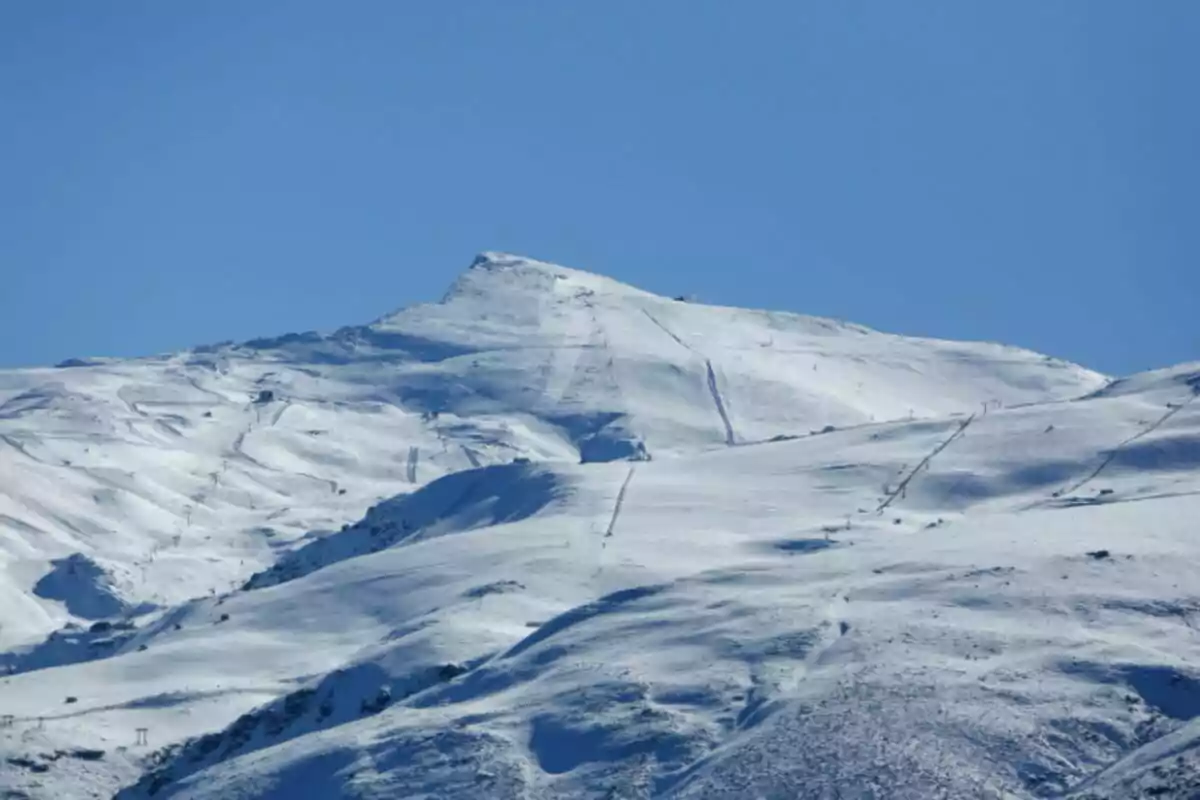 Una montaña nevada con varias pistas de esquí a la vista