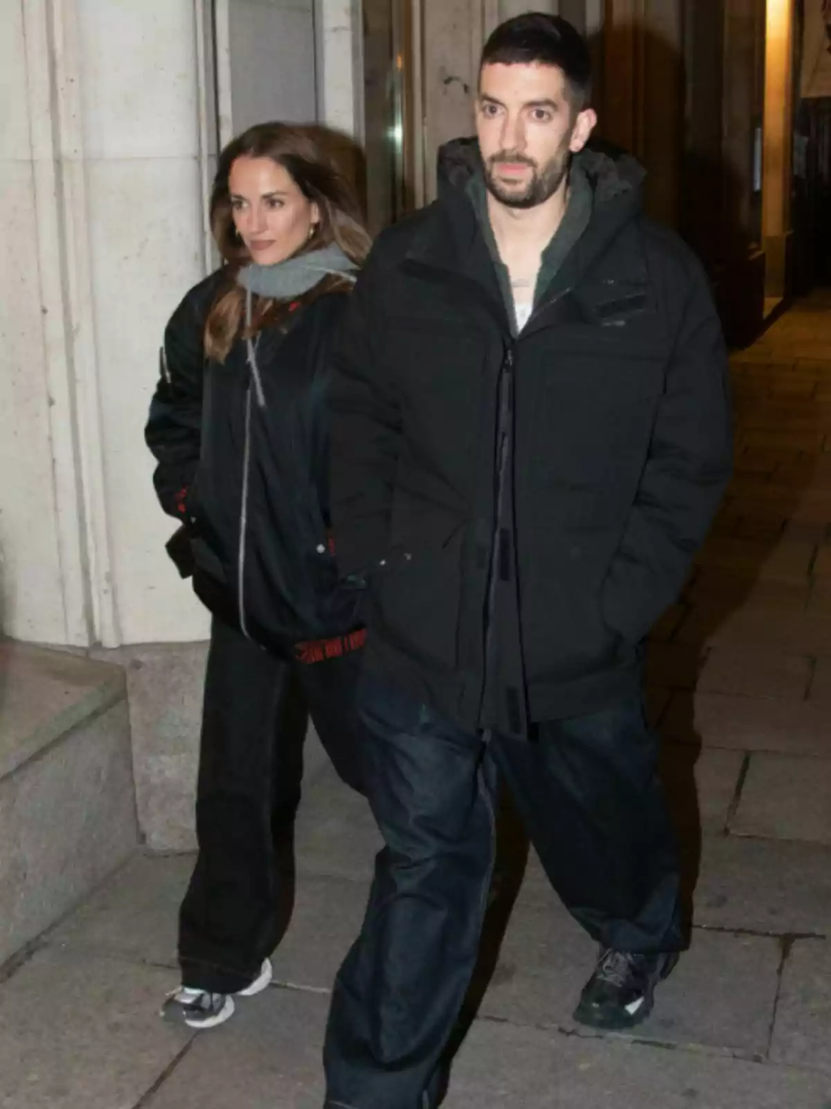 Silvia Alonso i David Broncano caminen per la vorera durant la nit vestint roba d’abric i fosca. Silvia Alonso i David Broncano caminen per la vorera durant la nit vestint roba d’abric i fosca.