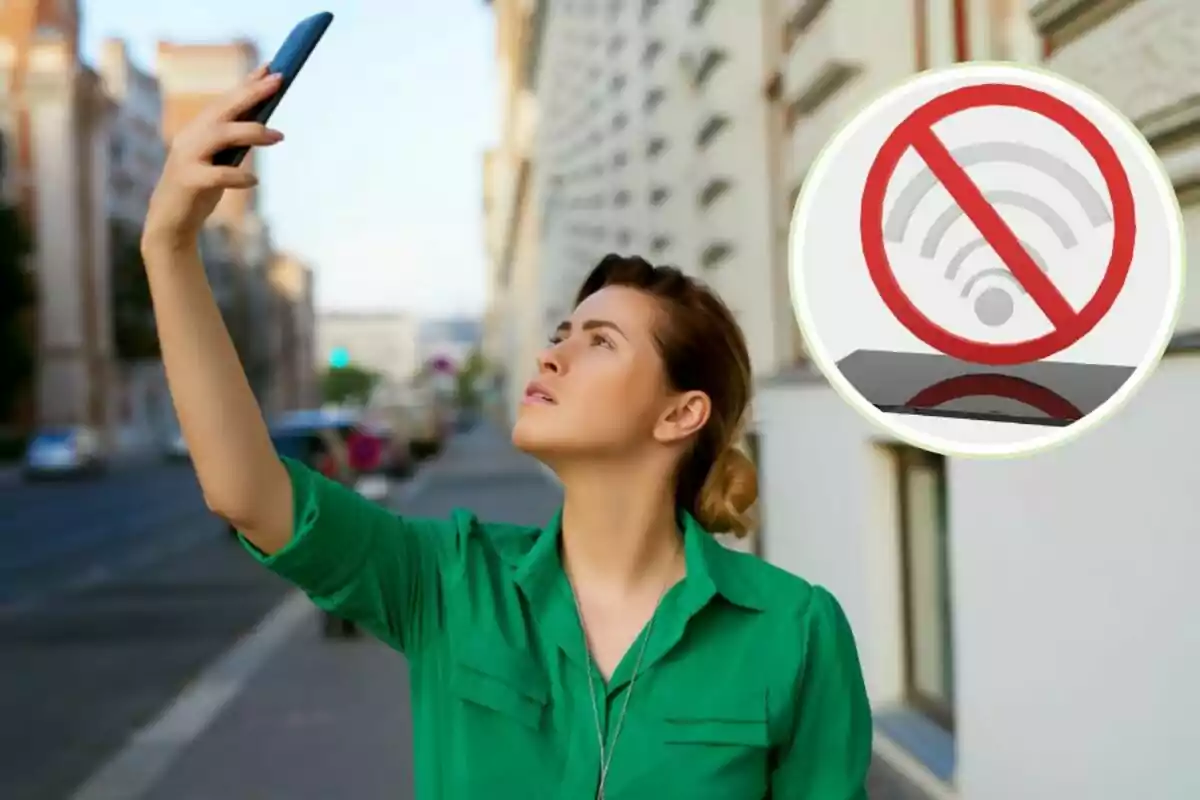 Dona aixecant el telèfon mòbil en un carrer, amb un símbol de prohibició de senyal Wi-Fi a la cantonada superior dreta.