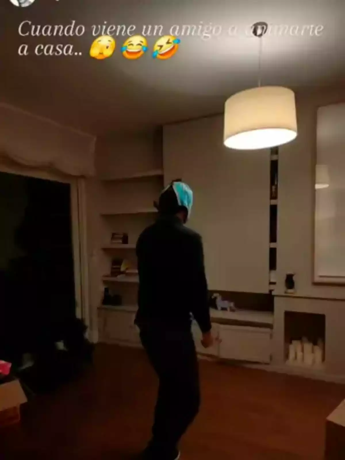 Un home amb una bossa al cap està dret en una sala il·luminada amb una làmpada penjant. Un home amb una bossa al cap està dret en una sala il·luminada amb una làmpada penjant.