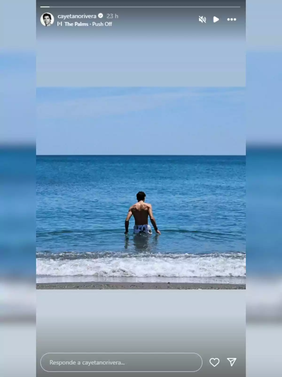 Cayetano Rivera d’esquena entrant al mar en una platja amb cel serè Cayetano Rivera d’esquena entrant al mar en una platja amb cel serè