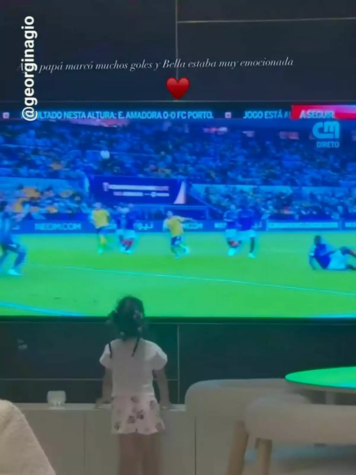 Una nena petita observa atentament un partit de futbol a la televisió. Una nena petita observa atentament un partit de futbol a la televisió.