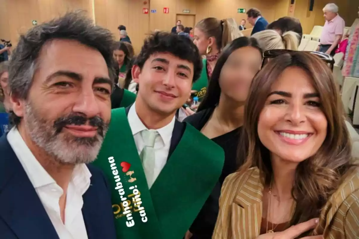 Un grup de persones somriu per a una foto en un esdeveniment de graduació, amb una persona portant una banda verda i un missatge de felicitació a la imatge. Un grup de persones somriu per a una foto en un esdeveniment de graduació, amb una persona portant una banda verda i un missatge de felicitació a la imatge.