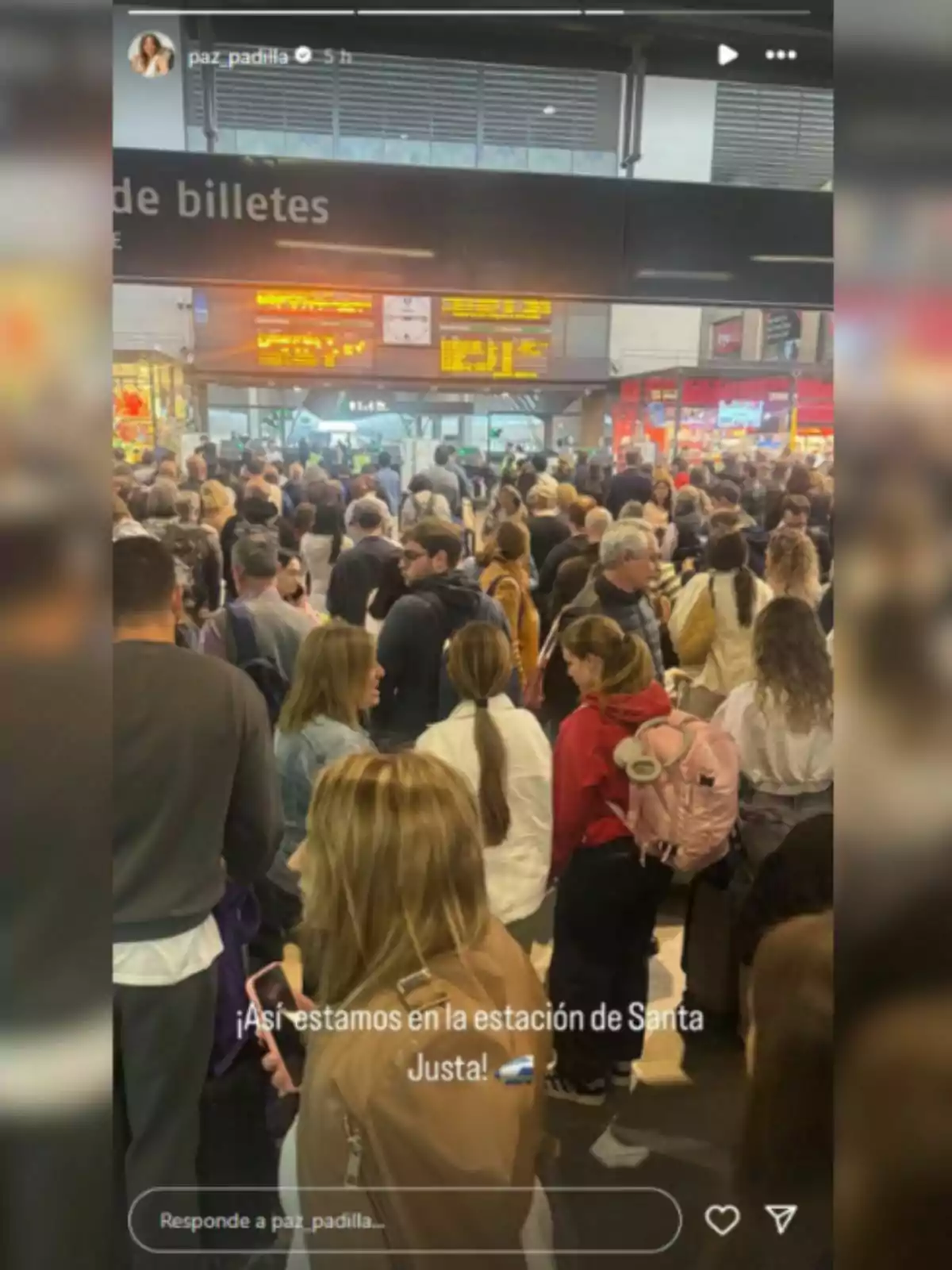 Una multitud de persones es troba a l'interior d'una estació de tren, amb un cartell d'informació de bitllets visible a la part superior. Una multitud de persones es troba a l'interior d'una estació de tren, amb un cartell d'informació de bitllets visible a la part superior.