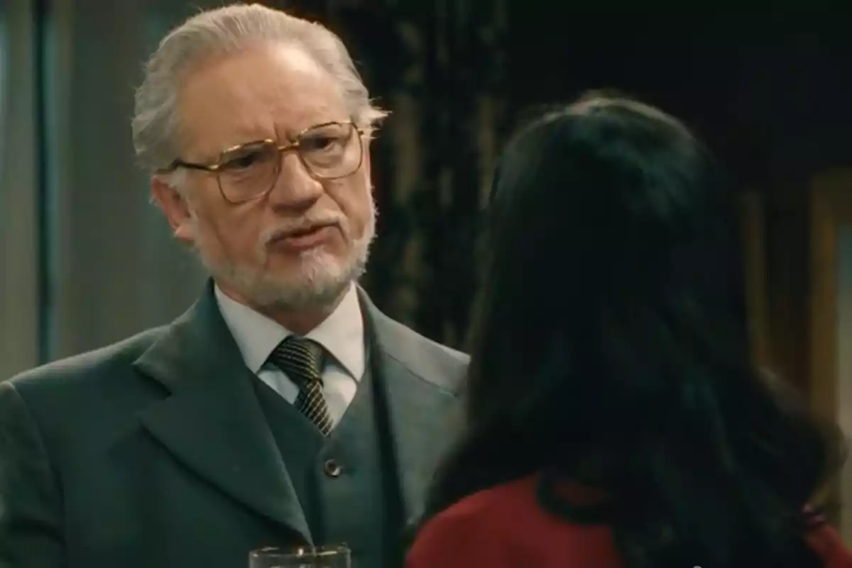Damián parlant amb una dona de cabell llarg i fosc en un ambient interior elegant. Captura de 'Sueños de libertad' Damián parlant amb una dona de cabell llarg i fosc en un ambient interior elegant. Captura de 'Sueños de libertad'