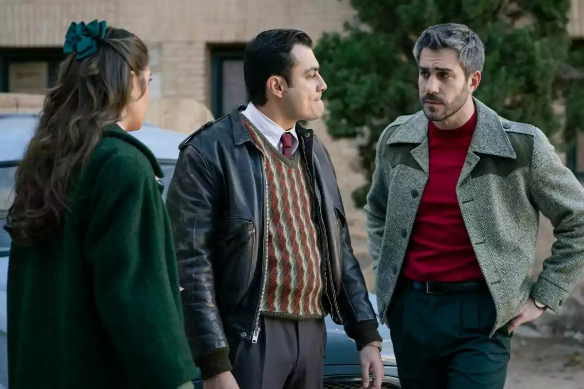 Dani Tatay, José Milán i Alba Brunet conversen a l'aire lliure, dos homes i una dona, tots vestits amb roba d'estil retro, amb un cotxe i un edifici de fons a Sueños de Libertad. Dani Tatay, José Milán i Alba Brunet conversen a l'aire lliure, dos homes i una dona, tots vestits amb roba d'estil retro, amb un cotxe i un edifici de fons a Sueños de Libertad.