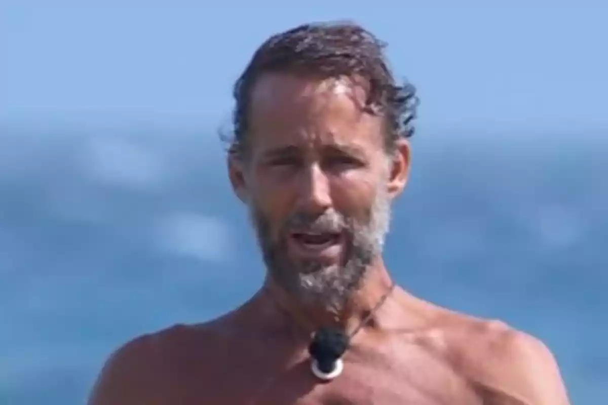 Álvaro Muñoz Escassi amb el tors nu davant del mar amb un micròfon al coll. Captura de 'Supervivientes'