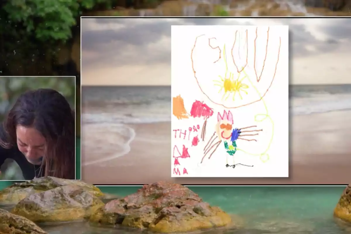 Anita apareix emocionada al costat d'un dibuix infantil acolorit que mostra un sol, una figura somrient i diverses formes abstractes, tot sobre un fons de platja amb roques i el mar. Captura de 'Supervivientes' Anita apareix emocionada al costat d'un dibuix infantil acolorit que mostra un sol, una figura somrient i diverses formes abstractes, tot sobre un fons de platja amb roques i el mar. Captura de 'Supervivientes'