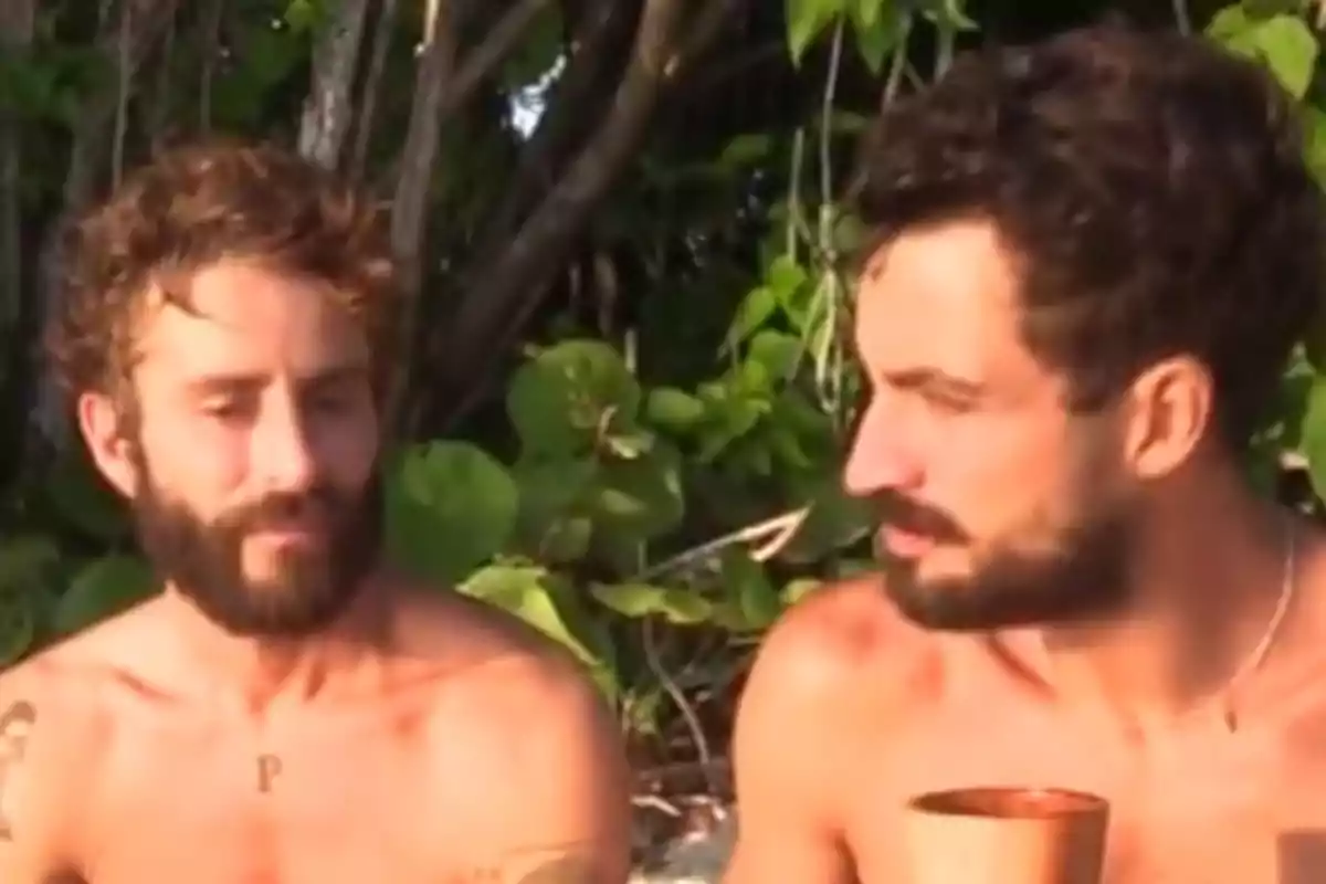 Pelayo Díaz i Joshua Velázquez estan asseguts a l'aire lliure, envoltats de vegetació, mentre un d'ells sosté un got. Captura de 'Supervivientes' Pelayo Díaz i Joshua Velázquez estan asseguts a l'aire lliure, envoltats de vegetació, mentre un d'ells sosté un got. Captura de 'Supervivientes'