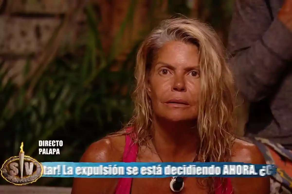 Makoke amb expressió seriosa, asseguda en un entorn selvàtic durant un programa de televisió en directe, amb una franja blava a la part inferior de la imatge que mostra text sobre una expulsió. Captura de 'Supervivientes' Makoke amb expressió seriosa, asseguda en un entorn selvàtic durant un programa de televisió en directe, amb una franja blava a la part inferior de la imatge que mostra text sobre una expulsió. Captura de 'Supervivientes'
