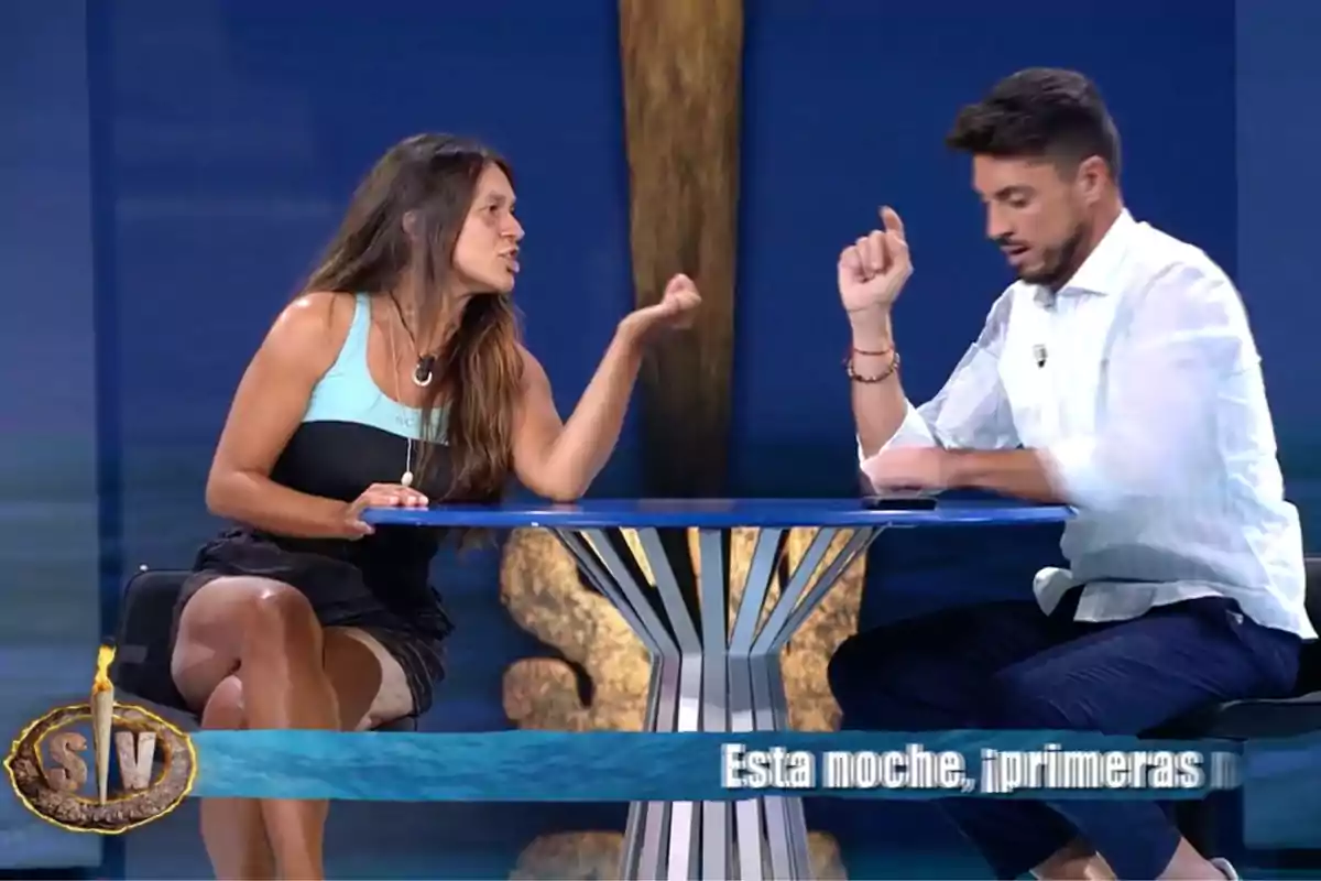 Laura Cuevas i Carlos Calderón assegudes en una taula blava discuteixen gesticulant intensament en un plató de televisió amb un fons blau i un logotip a la cantonada inferior esquerra. Captura de 'Supervivientes'. Laura Cuevas i Carlos Calderón assegudes en una taula blava discuteixen gesticulant intensament en un plató de televisió amb un fons blau i un logotip a la cantonada inferior esquerra. Captura de 'Supervivientes'.
