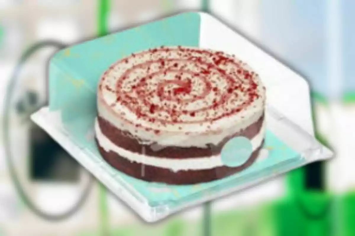 Un pastís de capes amb crema blanca i espolsat amb molles vermelles sobre un plat blau. Un pastís de capes amb crema blanca i espolsat amb molles vermelles sobre un plat blau.