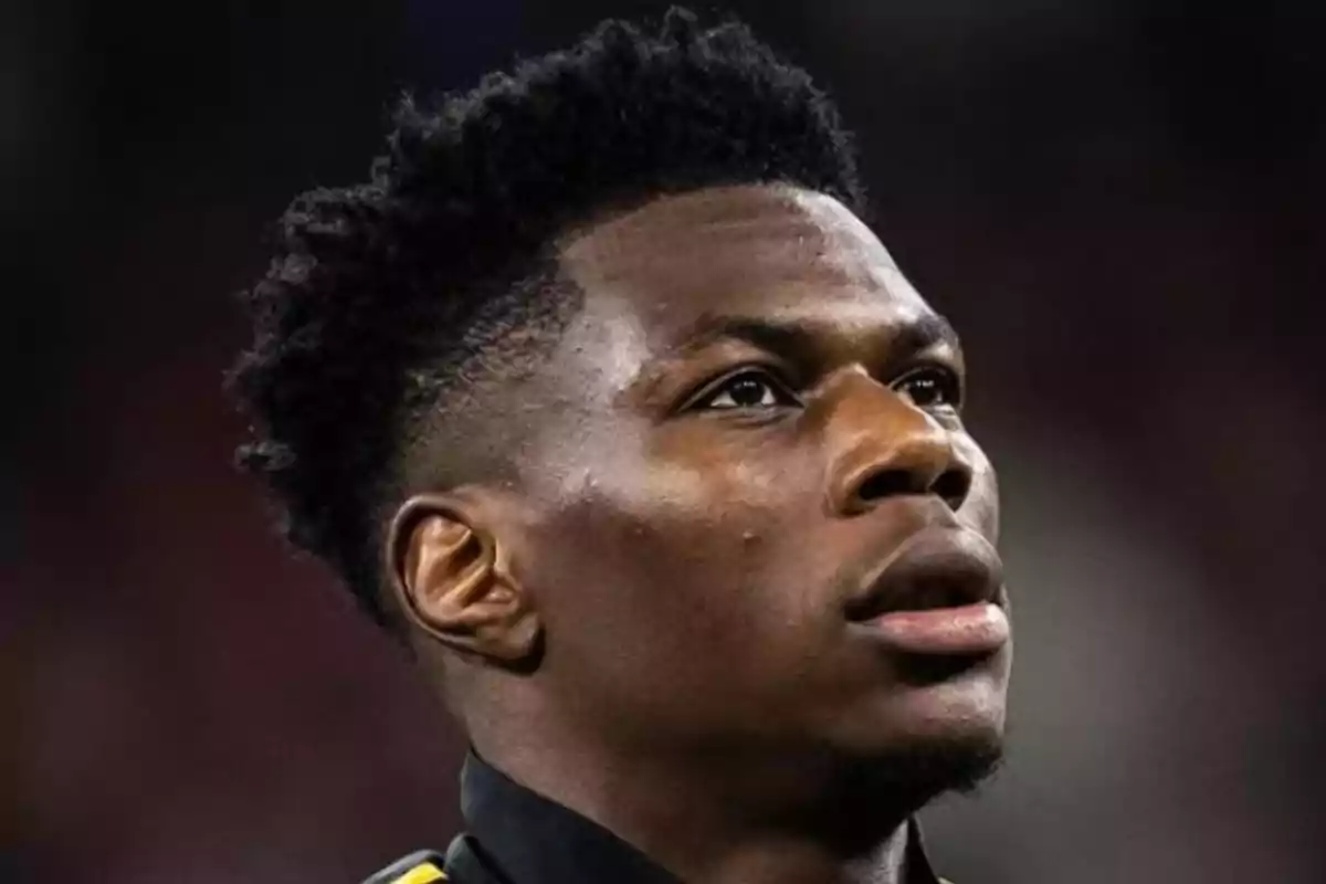 A man looking up with a serious expression and a dark background. A man looking up with a serious expression and a dark background.