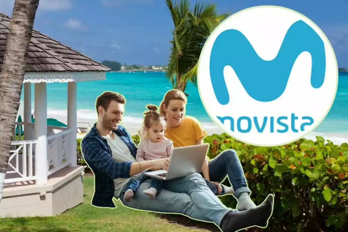 Una família asseguda a la gespa al costat de la platja usant un ordinador portàtil amb el logotip de Movistar a la cantonada superior dreta.