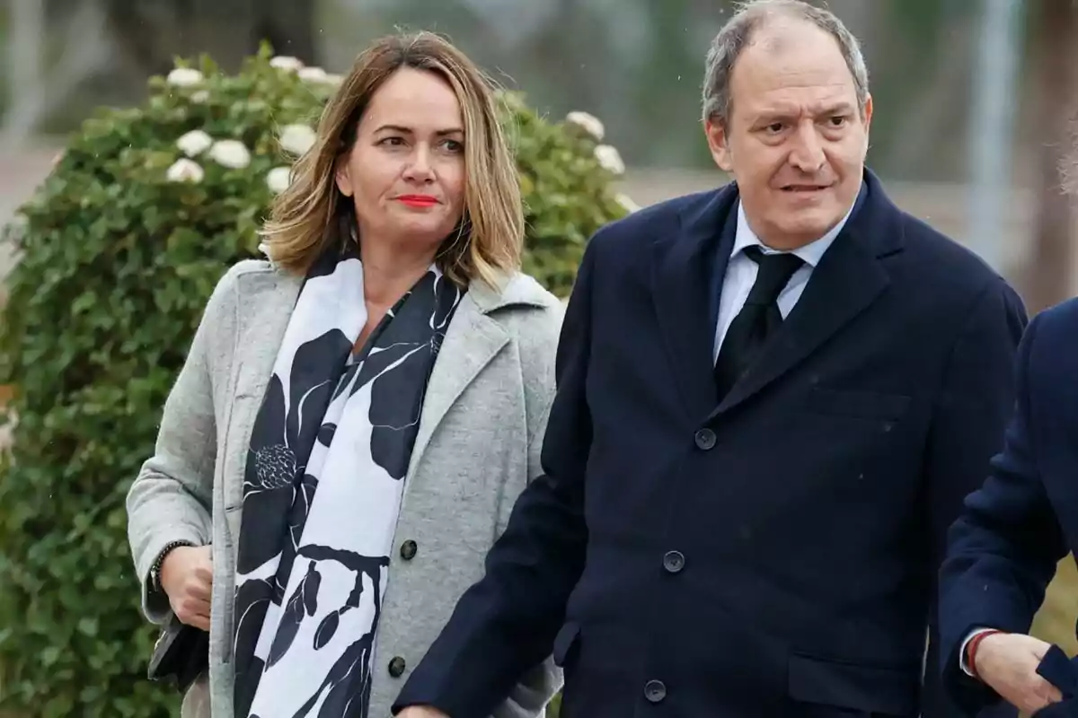 Teresa Ferrez and Juan Gomez Acebo walk together, both wearing dark coats.