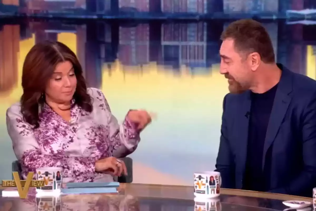 Javier Bardem i una presentadora conversen en un programa de televisió, asseguts en una taula amb tasses decorades i un fons de ciutat desenfocat. Captura de 'The View' Javier Bardem i una presentadora conversen en un programa de televisió, asseguts en una taula amb tasses decorades i un fons de ciutat desenfocat. Captura de 'The View'