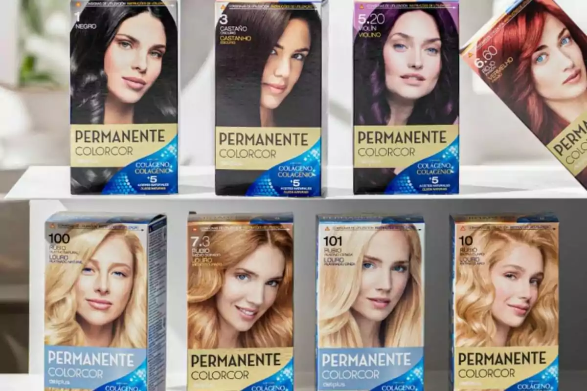 Cajas de tinte para el cabello de la marca Permanente Colorcor en varios tonos, incluyendo negro, castaño, violín, rojo, y diferentes rubios, dispuestas en dos filas sobre una superficie blanca.