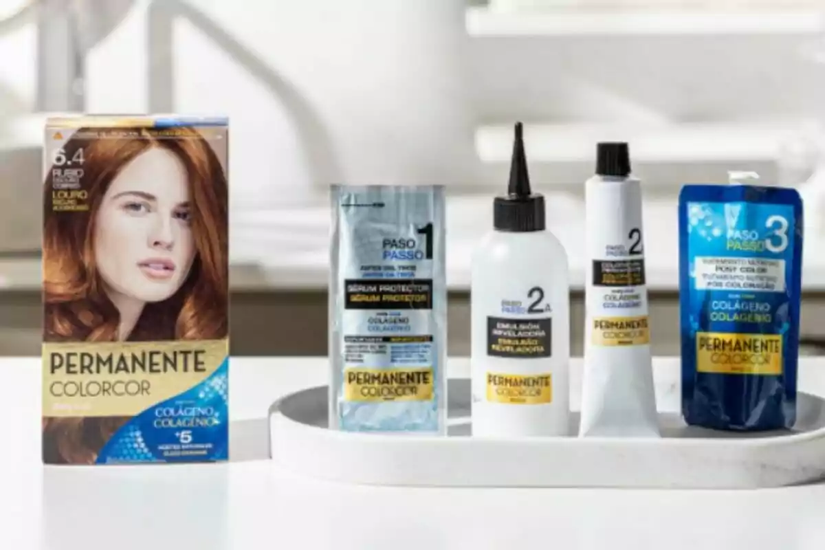 Caja de tinte para el cabello Permanente Colorcor con varios productos incluidos, como suero protector, emulsión reveladora y tratamiento nutritivo, todos presentados sobre una bandeja blanca.