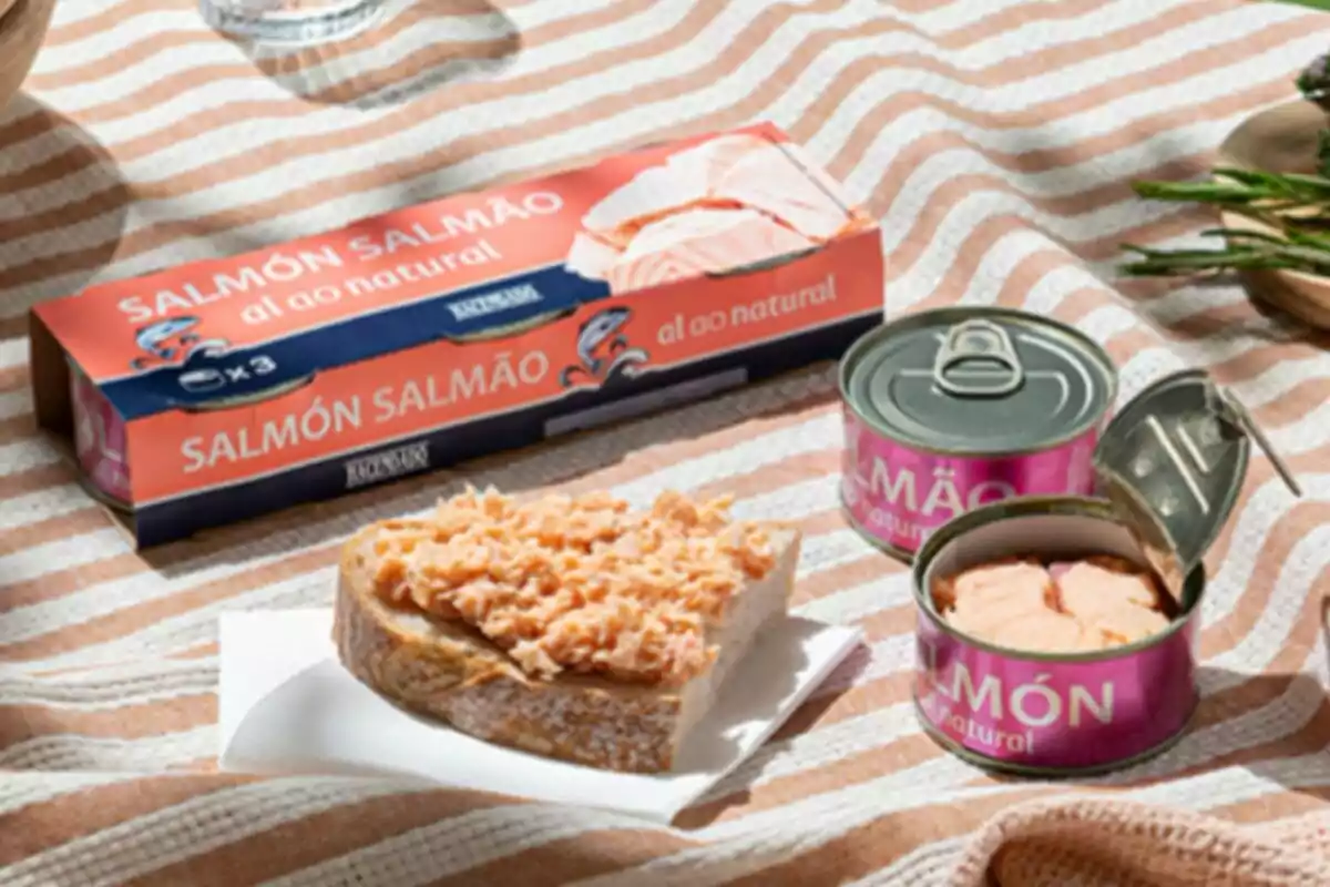 Una llauna de salmó al natural de Mercadona oberta al costat d'una llesca de pa amb salmó esmicolat sobre un mantell de ratlles. Una llauna de salmó al natural de Mercadona oberta al costat d'una llesca de pa amb salmó esmicolat sobre un mantell de ratlles.