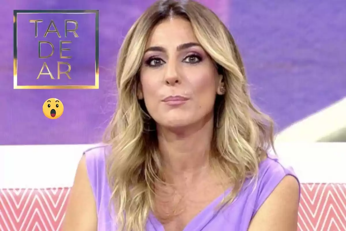 Una persona amb cabell ros i ondulat, vestida de lila, apareix en un programa de televisió amb un fons morat i un logotip que diu "TARDEAR".