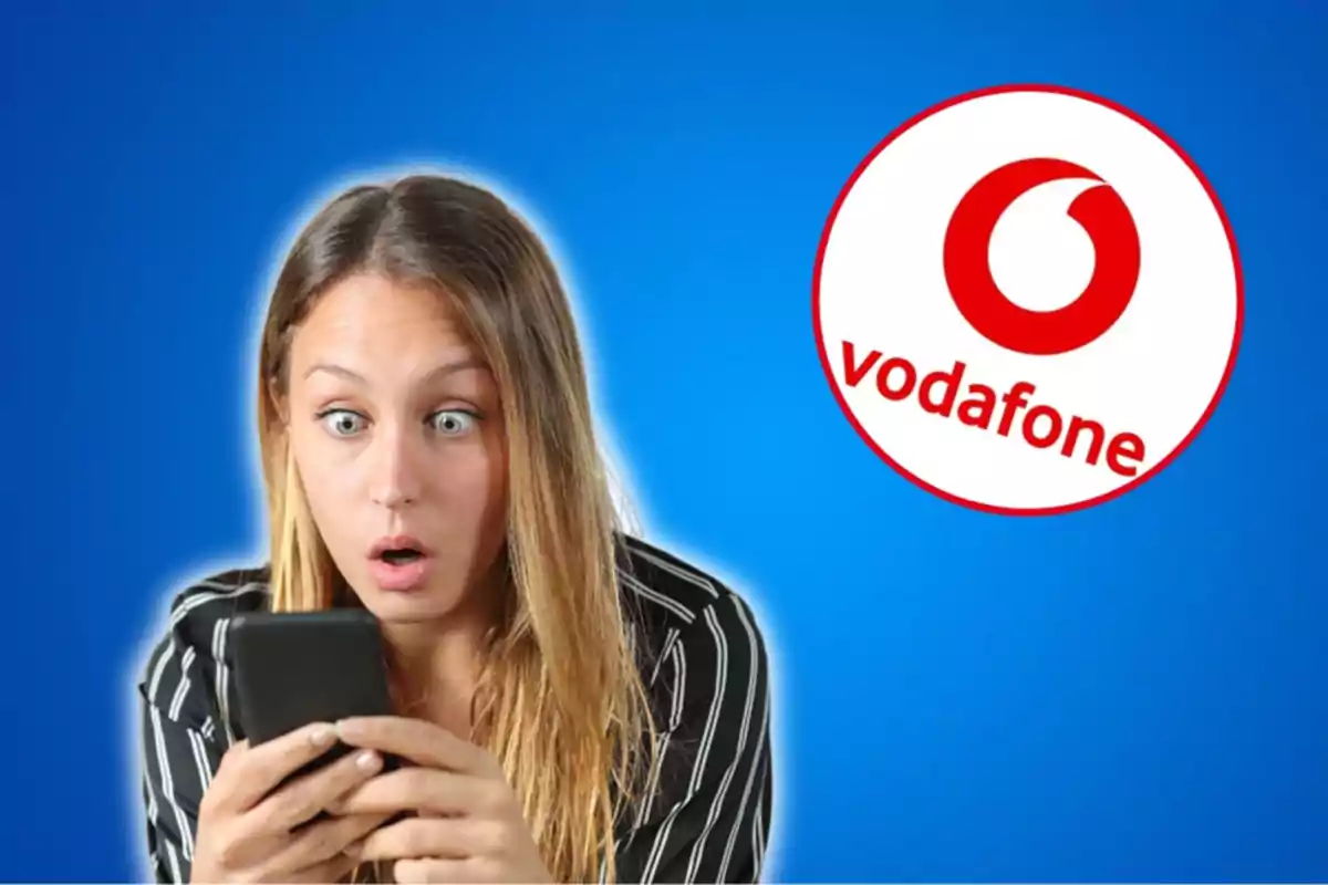Dona sorpresa mirant el telèfon amb el logotip de Vodafone al fons.