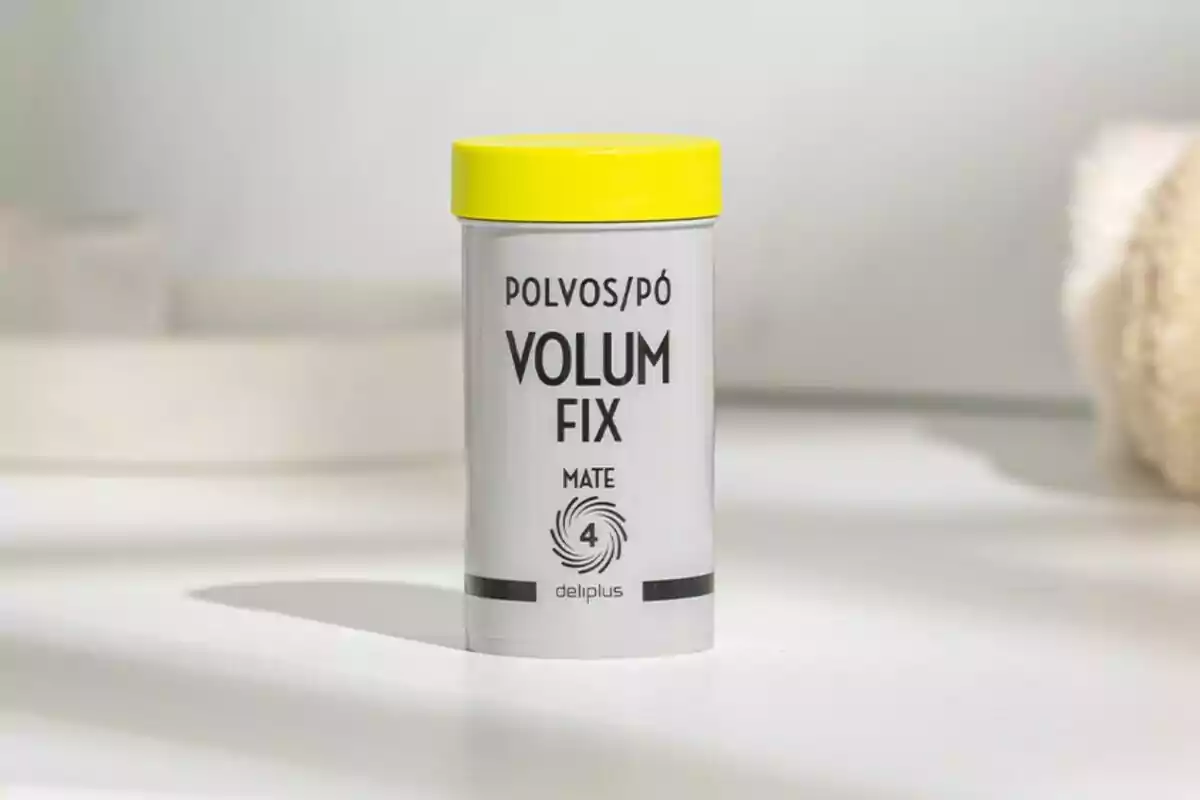 Envàs de pols Volum Fix mat de la marca Deliplus amb tapa groga sobre una superfície blanca