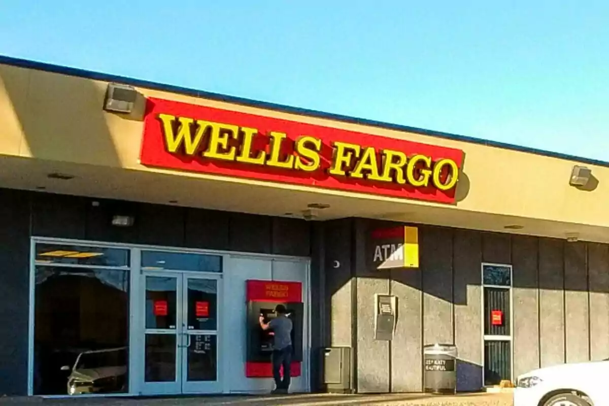 A person using an ATM at a Wells Fargo branch. A person using an ATM at a Wells Fargo branch.
