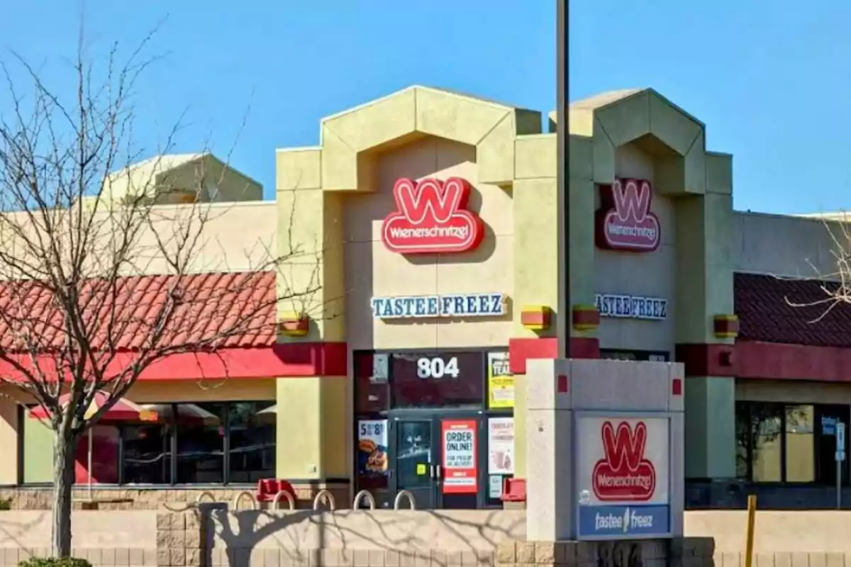 Façana d’un restaurant Wienerschnitzel amb rètol de Tastee Freez i arbres sense fulles al davant Façana d’un restaurant Wienerschnitzel amb rètol de Tastee Freez i arbres sense fulles al davant