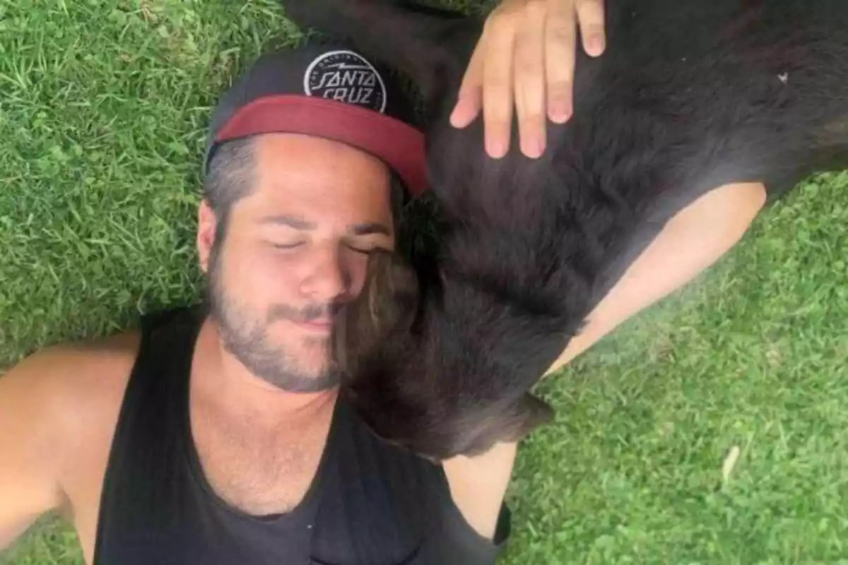 Imatge de la parella d'Elisenda Carod, Xavi Fernández estirat sobre la gespa amb la seva gossa Lola