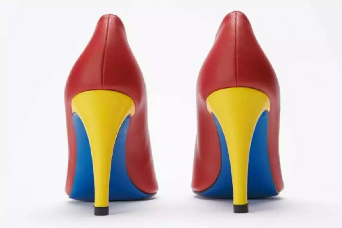 Zapatos de tacón alto en colores rojo, amarillo y azul vistos desde atrás.