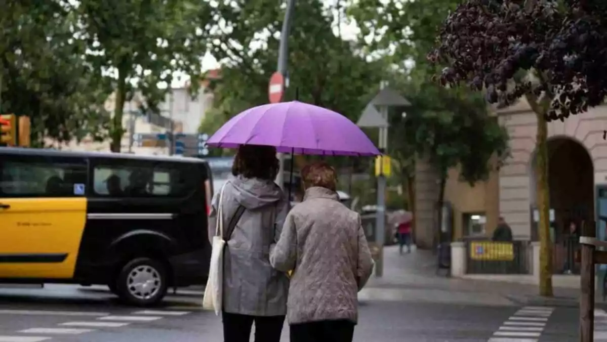 Imatge de dues persones passejant sota la pluja a Barcelona