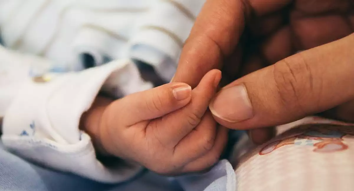 Un bebè i mare agafats de les mans
