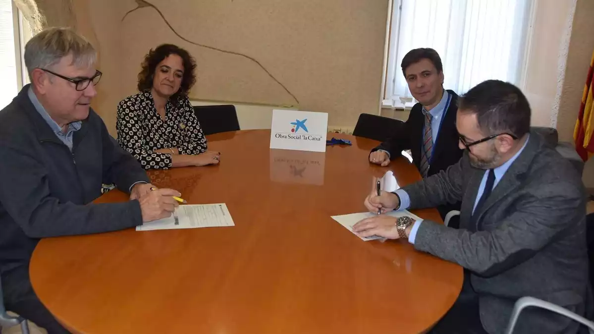 L'alcalde Eduard Rovira i la regidora d'Acció Social Margaret Rovira signen l'acord amb responsables de CaixaBank.