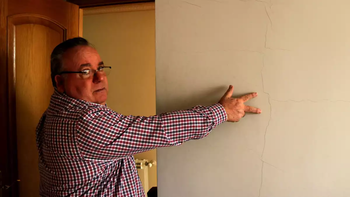 José Miguel Monllaó mostrant una esquerda a la paret d'una habitació de la seva casa d'Amposta causada pels terratrèmols del projecte Castor
