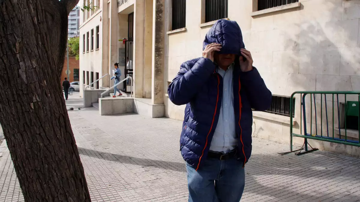 Un dels acusats de la xarxa d’abús de menors i pornografia infantil destapada a Tortosa sortint de l'Audiència de Tarragona tapant-se la cara amb una caputxa
