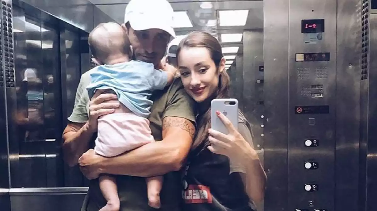 Hugo con su bebé en brazos y junto a Adara en un ascensor