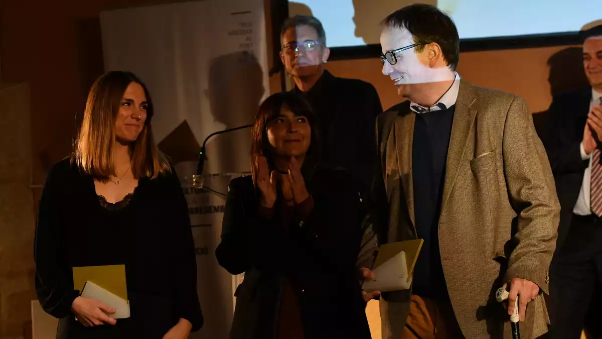 Judit Sabaté i Dídac Montoliu, amb Coia Ballesté al centre, rebent el Premi de Periodisme Mané i Flaquer 2019