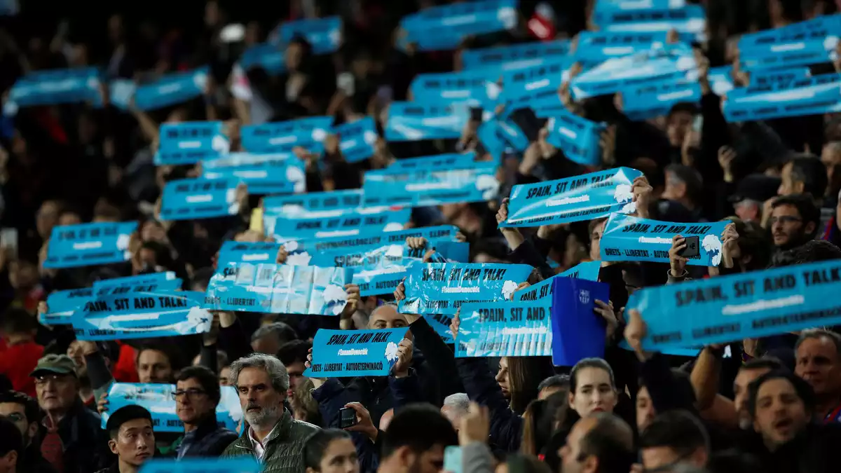 Aficionats del Barça aixecant pancartes de Tsunami Democràtic durant el Clàssic del 18 de desembre de 2019