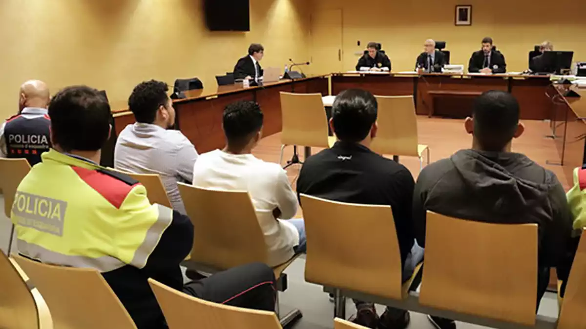D'esquenes, els quatre acusats d'agredir sexualment una noia durant una baralla a Girona. Foto del judici del 18 de desembre del 2019