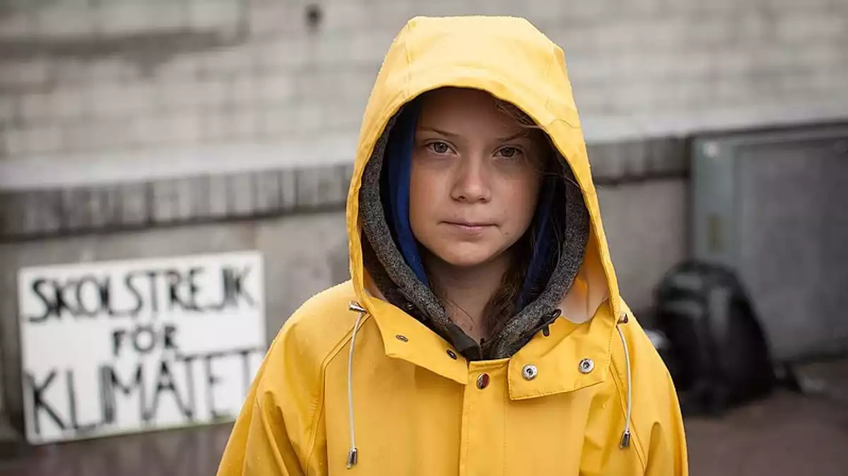 Greta Thunberg, enfundada en un impermeable groc.