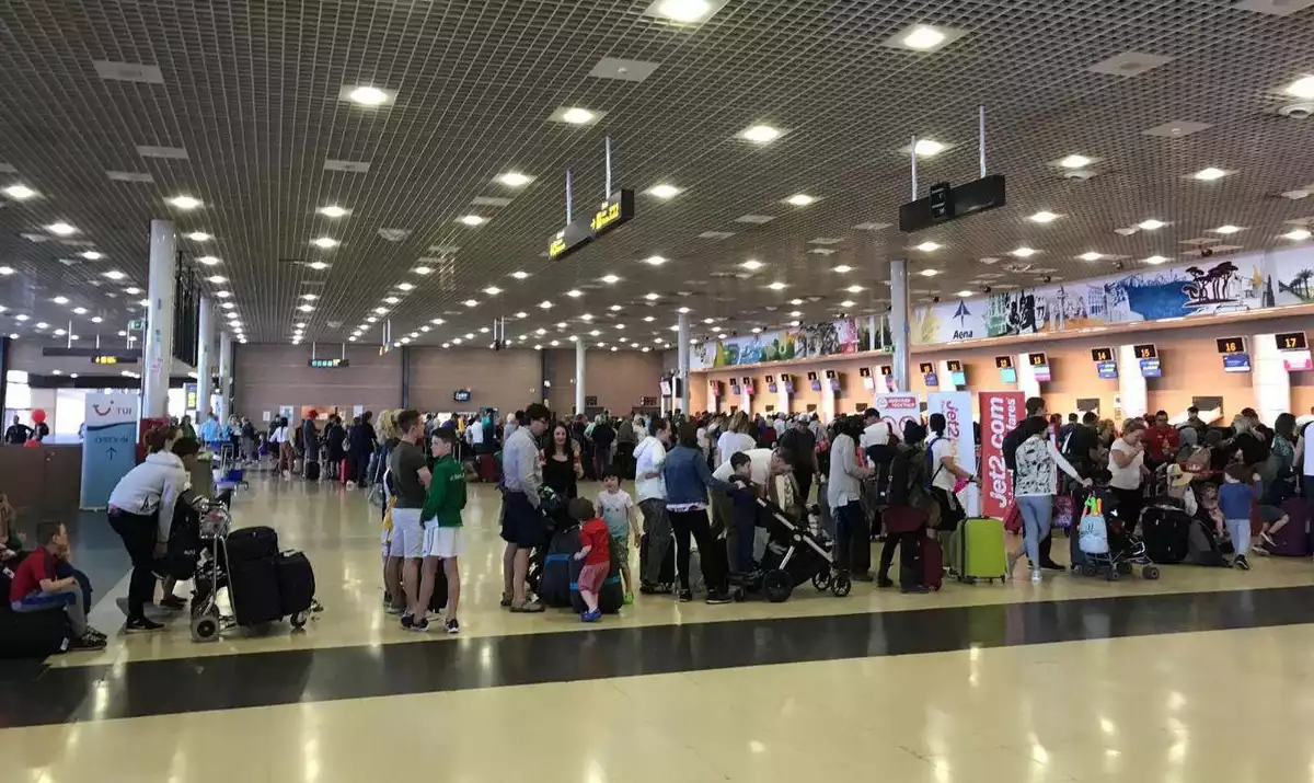 La terminal d'embarcament de l'aeroport de Reus plena de passatgers fent cua per facturar