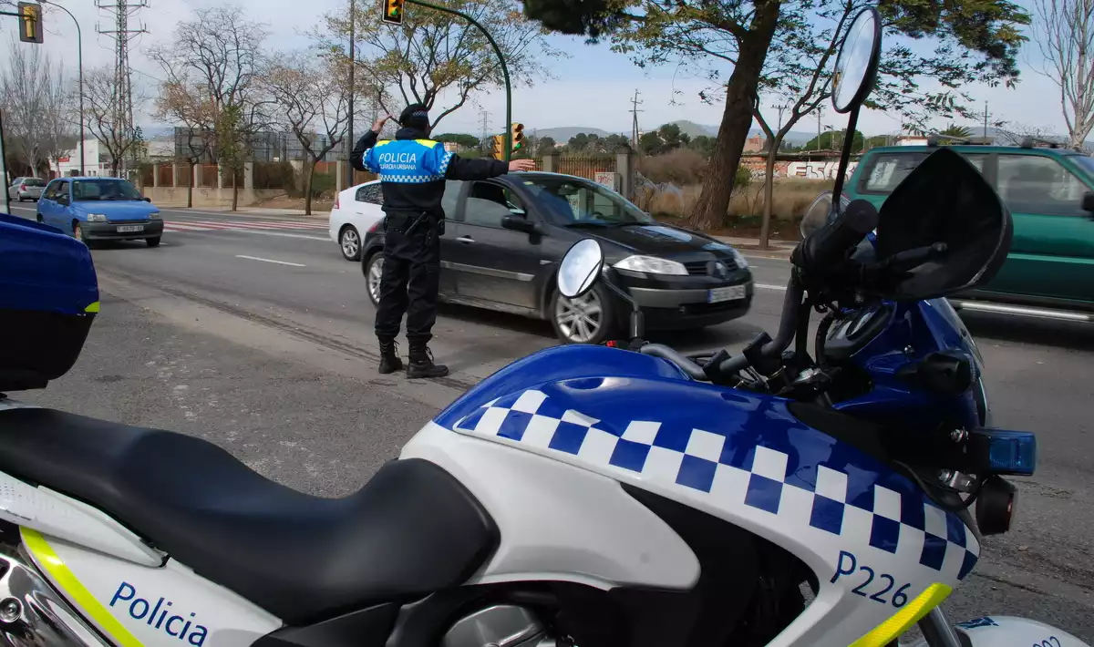 Una moto de la Guàrdia Urbana de Reus i un agent a la carretera d'Alcolea durant un control