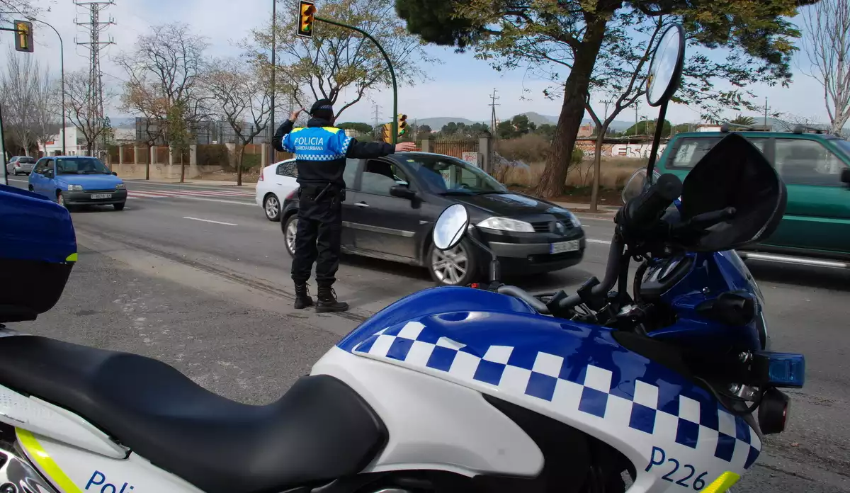 Una moto de la Guàrdia Urbana de Reus i un agent a la carretera d'Alcolea durant un control