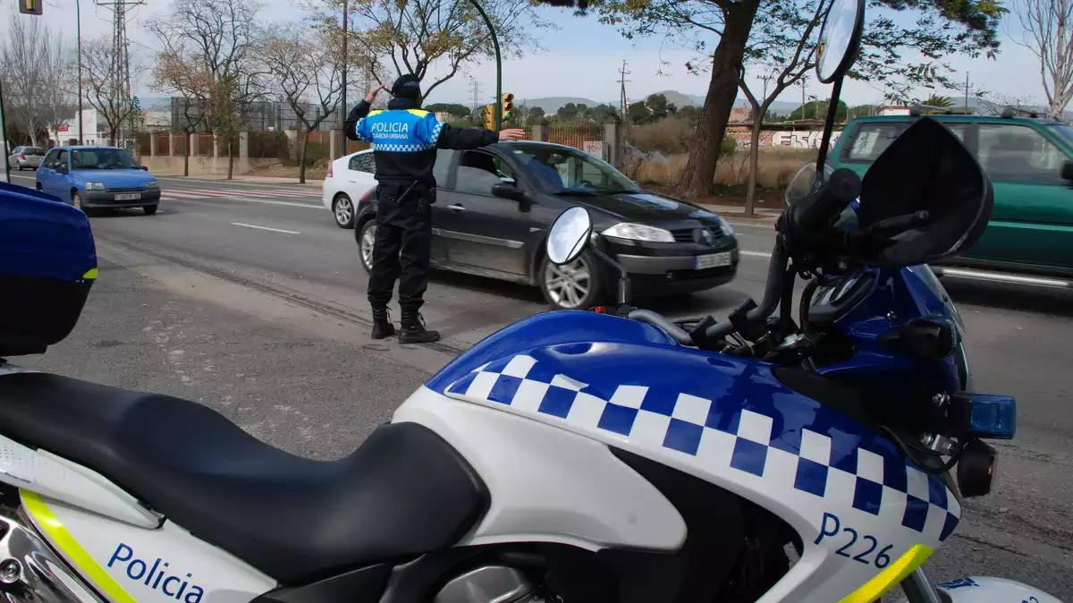 Una moto de la Guàrdia Urbana de Reus i un agent a la carretera d'Alcolea durant un control