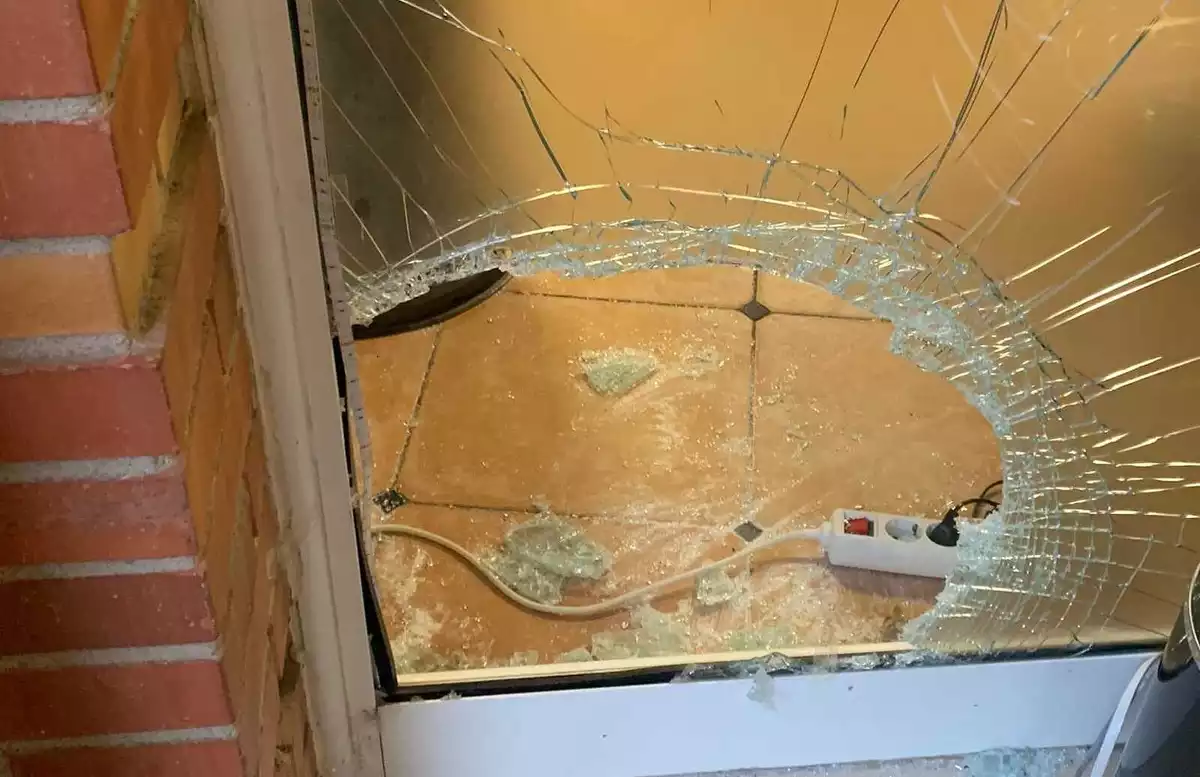 Imatge de la porta del local, destrossada per una pedrada