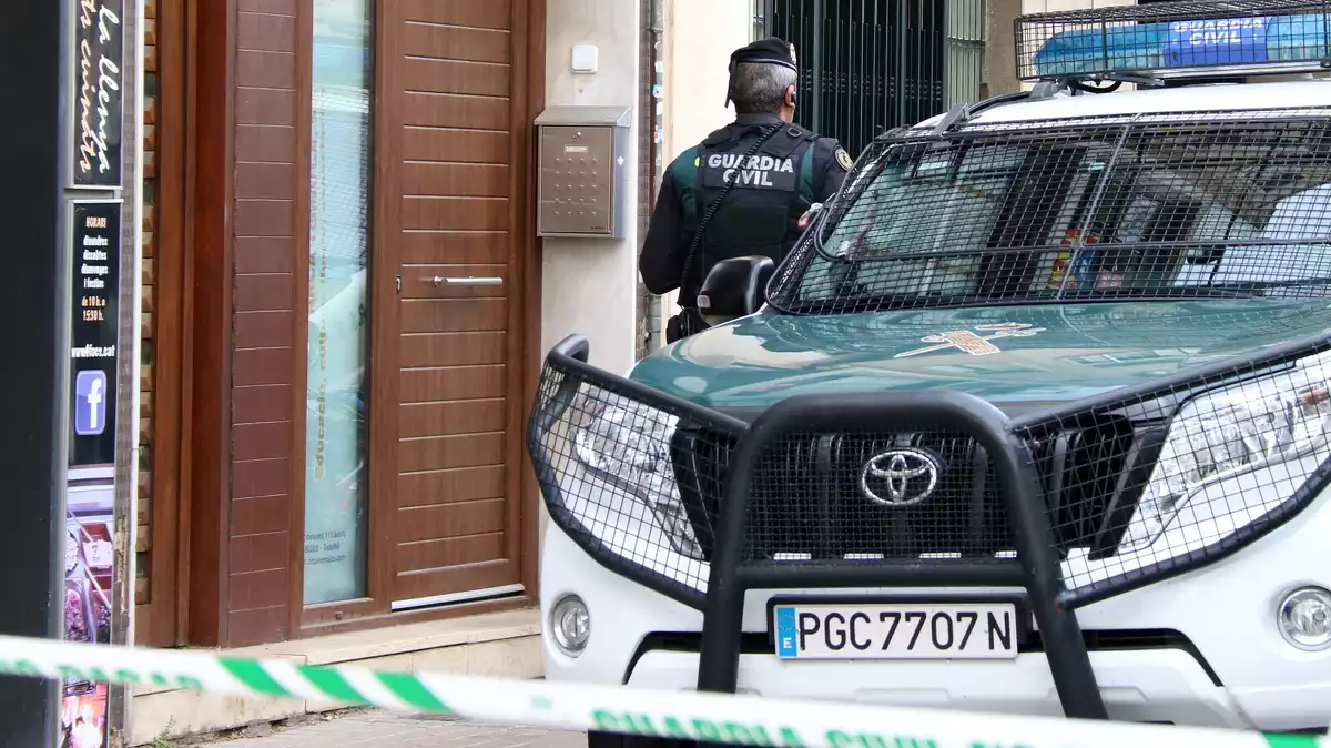 Un agent de la Guàrdia Civil al costat d'un cotxe del mateix cos policial